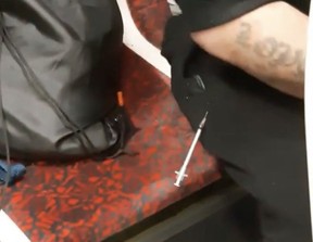 A needle sticks out of the leg of a drug user on a TTC streetcar in this undated photo