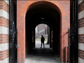 A man walks through a gate to the Yard at Harvard University in Cambridge, Mass., March 10, 2020.