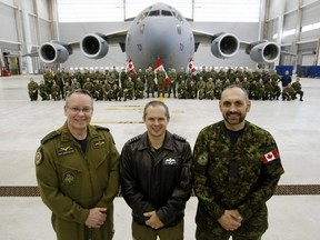 Brig.-Gen. Iain Huddleston, left, Lt.-Col. Bryce Graham and Chief Warrant Officer Eric Lafond stand before members of 429 Transport Squadron and the unit's most-travelled aircraft, at CFB Trenton, Ont. Oct. 17, 2018.