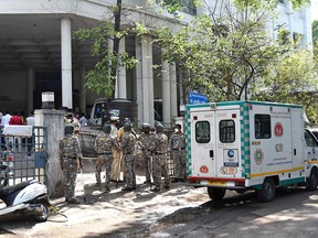 Police personnel stand guard at the entrance of the Zakir Hussain Hospital after an oxygen tanker leaked outside the hospital, in Nashik on April 21, 2021.