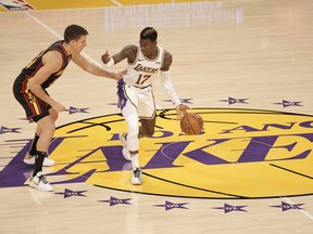 Dennis Schroder, left, of the Los Angeles Lakers dribbles against Bogdan Bogdanovic of the Atlanta Hawks during the first period at Staples Center on March 20, 2021 in Los Angeles, Calif.