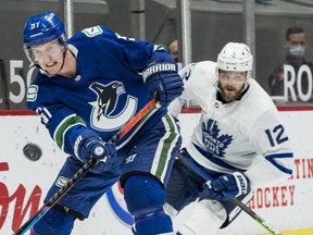 Toronto Maple Leafs forward Alex Galchenyuk (12) checks Vancouver Canucks defenceman Tyler Myers (57) on April 18, 2021.