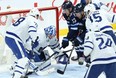 Winnipeg Jets forwards Pierre-Luc Dubois (centre) and Paul Stastny (centre right) try to jam a puck past Toronto Maple Leafs goaltender Jack Campbell during last night’s game in Winnipeg. KEVIN KING/Postmedia Network