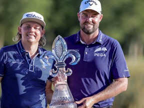 Cameron Smith (left) and Marc Leishman pose with the Zurich Classic trophy and belts after winning the Zurich Classic of New Orleans on Sunday.