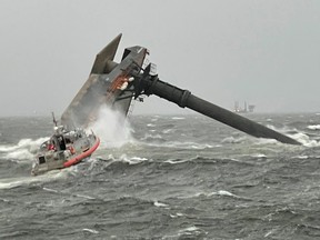 A Coast Guard boat crew heads toward a capsized 175-foot commerical lift boat while searching for people in the water south of Grand Isle, Louisiana, April 13, 2021.