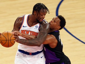Julius Randle of the Knicks (left) is guarded by Raptors' Kyle Lowry during their game at Madison Square Garden on April 11, 2021 in New York City.