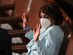U.S. Rep. Maxine Waters wears a face mask as she talks to other members of congress while waiting in her seat before U.S. President Joe Biden arrives to deliver his first address to a joint session of Congress at the U.S. Capitol in Washington, D.C., on April 28, 2021.