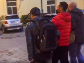 This image grabbed from a video handout on April 22, 2021 by the Italian State Police shows officers escorting a man, identified only as Endri E.