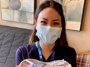 Humber River Hospital nurse Brenda Lotakoun, part of the hospital's mobile vaccination unit, holds Moderna vaccines ready for residents of Richview highrise