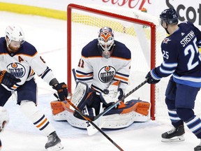 Oilers goaltender Mike Smith blocks a shot by Jets centre Paul Stastny (right) in the second period at Bell MTS Place in Winnipeg, Monday, April 26, 2021.