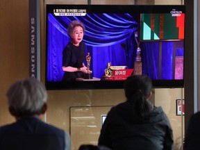 People watch a TV screen showing South Korean actress Youn Yuh-Jung at the Seoul Railway Station in Seoul, South Korea, Monday, on April 26, 2021.