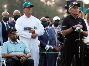 Wayne Player, the son of South Africa’s Gary Player, holds a box of golf balls as he stands behind honourary starters Lee Elder of the U.S. and Gary Player during the ceremonial start on the first day of play of the Masters Tournament.