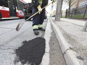A City of Toronto work crew repairing potholes on northbound Jane St. near Dundas St. West. on Saturday April 17, 2021.