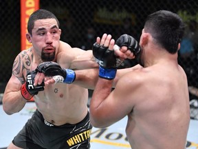 In this handout photo, Robert Whittaker of Australia, left, punches Kelvin Gastelum in a middleweight fight during the UFC Fight Night event at UFC APEX on April 17, 2021 in Las Vegas, Nevada.