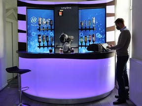 Chief Sales Officer Gery Colombo taps a display to order a drink at the Barney Cocktail Bar of the Swiss F&P Robotics company in Zurich, Switzerland, April 16, 2021.