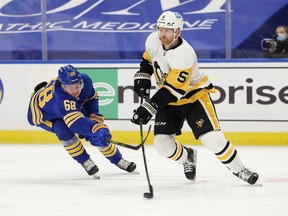 Buffalo Sabres right wing Victor Olofsson, right, reaches to try and knock the puck off the stick of Pittsburgh Penguins defenseman Zach Trotman during the second period at KeyBank Center in Buffalo, N.Y., April 17, 2021.