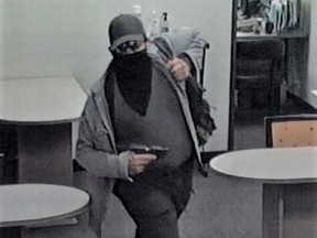 A suspect holding a weapon is seen in a still image from surveillance camera video taken inside the office of a mobile home realty company which was the scene of a mass shooting in Orange, California, March 31, 2021.