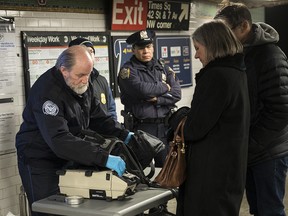 Members of the Transportation Security Administration and New York City Police Department check the bags of passengers as they enter the Times Square subway station during the evening rush hour, December 11, 2017 in New York.