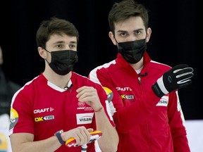 Wearing masks on the ice, Team Switzerland skip 
Peter de Cruz (right) and  fourth-rock thrower Benoit Schwarz discuss strategy during their qualification game against the United States as the world men's curling championship resumed April 11, 2021, in Calgary.