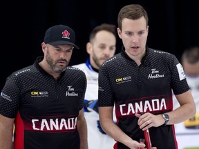 Team Canada skip Brendan Bottcher (right) and third Darren Moulding discuss their options during a win over Italy during Draw 14 of the world men's curling championship in Calgary on April 6, 2021.