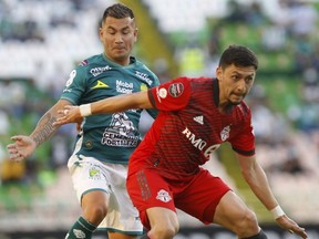 Marky Delgado of Toronto FC, front, fights for the ball with Jean Meneses of Mexico's Leon during a Concacaf Champions League soccer match in Leon, Mexico, on Wednesday. AP PHOTO