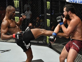 A handout image released by the Ultimate Fighting Championship (UFC) on July 12, 2020, shows  Kamaru Usman (left) kicking Jorge Masvidal in their welterweight championship fight during the UFC 251 event at UFC Fight Island in Abu Dhabi's Yas Island.