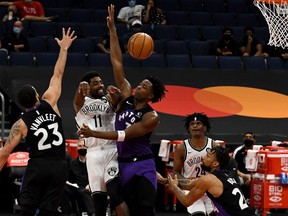 Brooklyn Nets' Kyrie Irving passes the ball as Raptors' Fred VanVleet (left) and OG Anunoby defend during the second quarter at Amalie Arena in Tampa, Fla., on Wednesday, April 21, 2021.