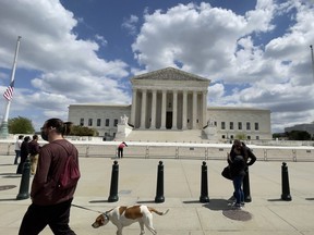 People walk past the U.S. Supreme court building in Washington D.C. on April 17, 2021.