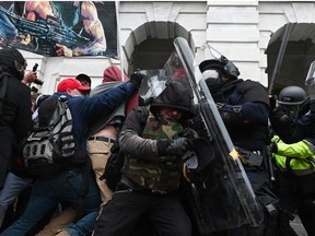 In this file photo taken on January 6, 2021 riot police push back a crowd of supporters of US President Donald Trump after they stormed the Capitol building in Washington, DC.