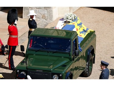 Members of the armed forces pay tribute to the coffin of Britain's Prince Philip, Duke of Edinburgh in the quadrangle ahead of the ceremonial funeral procession of  to St George's Chapel in Windsor Castle in Windsor, west of London, on April 17, 2021. - Philip, who was married to Queen Elizabeth II for 73 years, died on April 9 aged 99 just weeks after a month-long stay in hospital for treatment to a heart condition and an infection. (Photo by Adrian DENNIS / POOL / AFP)