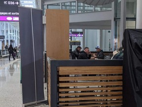 Unmasked diners enjoy a meal at a restaurant inside Terminal 1 of Toronto Pearson Airport in April. Airports are specifically exempted from provincial prohibitions on indoor dining.