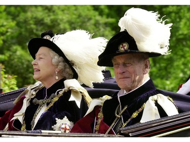 Queen Elizabeth II and Prince Phillip, the Duke of Edinburgh, wearing their Order of the Garter robes, ride in an open-topped carriage to Windsor Castle following the Garter Ceremony, June 18, 2001.