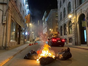 People take part in an anti-curfew protest in Montreal on Sunday April 11, 2021. Hundreds of people gathered in Old Montreal tonight in defiance of a new 8 p.m. curfew.