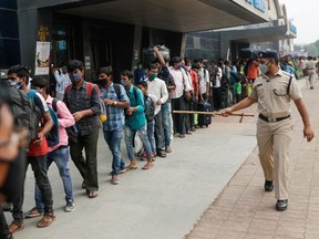 A police officer points at people in line at a railway station amidst the spread of the coronavirus disease (COVID-19) in Mumbai, India, April 11, 2021.