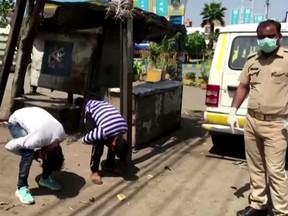 Two men are seen being punished by police in Mumbai, India, for breaking COVID-19 rules.