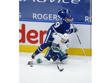 Toronto Maple Leafs Jason Spezza C (19) checks Vancouver Canucks Nils Hoglander LW (36) off the puck during the third period in Toronto on Thursday April 29, 2021. Jack Boland/Toronto Sun/Postmedia Network