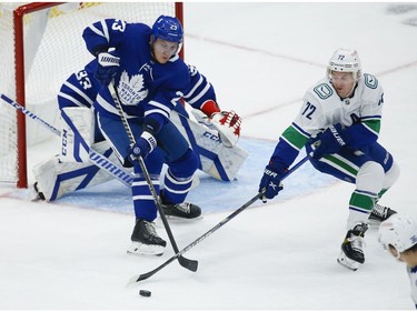 Toronto Maple Leafs Travis Dermott D (23) keeps the puck away from Vancouver Canucks Travis Boyd C (72) during the second period in Toronto on Thursday April 29, 2021. Jack Boland/Toronto Sun/Postmedia Network