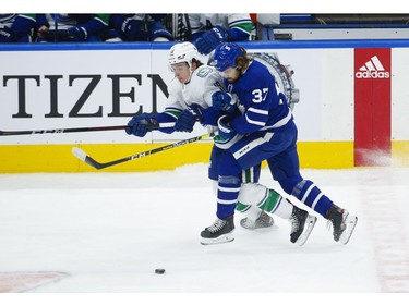 Toronto Maple Leafs Timothy Liljegren D (37) collides with Vancouver Canucks Jake Virtanen LW (18) during the first period in Toronto on Thursday April 29, 2021. Jack Boland/Toronto Sun/Postmedia Network