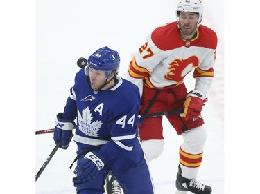 Toronto Maple Leafs Morgan Rielly D (44) just missing the floating puck with Calgary Flames Josh Leivo LW (27) during the first period in Toronto on Tuesday April 13, 2021. Jack Boland/Toronto Sun/Postmedia Network