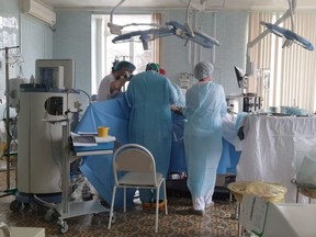 Doctors and nurses perform a surgery at a local clinic of cardiac surgery in the city of Blagoveshchensk, Russia April 2, 2021. Russian doctors stayed behind in a burning hospital on April 2, 2021 to complete open heart surgery as a large fire broke out on the roof moments after they had opened up their patient.