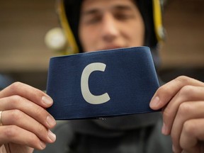 Djordje Vukicevic, duty firefighter, poses with Cristiano Ronaldo's armband which the Portugal captain threw on the pitch after his goal was disallowed in a World Cup qualifier against Serbia, at the Belgrade's firefighting brigade headquaters, Serbia, April 1, 2021.