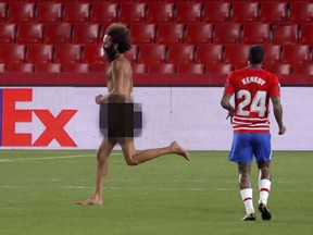 A streaker runs across the field during a Manchester United soccer game on Thursday, April 8, 2021.