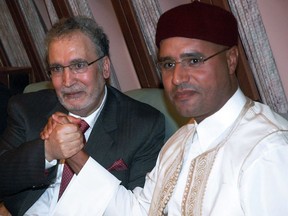 Libyan leader Moamer Kadhafi's son Seif al-Islam (R) holds hands with freed Lockerbie bomber Abdelbaset Ali Mohmet al-Megrahi, the sole Libyan convicted over the 1988 Pan Am jetliner bombing, aboard the Libyan presidential plane that brought him back home in Tripoli late on August 20, 2009.