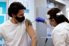 Canada's Prime Minister Justin Trudeau is inoculated with AstraZeneca's vaccine against coronavirus disease (COVID-19) at a pharmacy in Ottawa, Ontario, Canada, on Friday, April 23, 2021.
