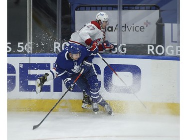Toronto Maple Leafs Zach Hyman C (11) and Montreal Canadiens Alexander Romanov D (27) collide along the boards during the first period in Toronto on Wednesday April 7, 2021. Jack Boland/Toronto Sun/Postmedia Network