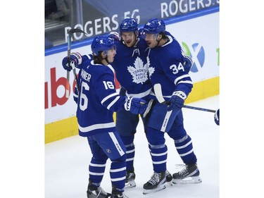 Toronto Maple Leafs Zach Hyman C (11) is congratulated by teammates Auston Matthews C (34) and  Mitch Marner RW (16)during the third period in Toronto on Wednesday April 7, 2021. Jack Boland/Toronto Sun/Postmedia Network