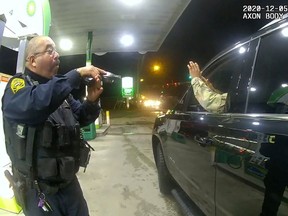 U.S. Army 2nd Lieutenant Caron Nazario raises his hands at a gas station during a violent traffic stop by Windsor, Virginia police officers Joe Gutierrez (L) and Daniel Crocker in a still image from Crocker's body camera taken in Windsor, Virginia, U.S. Dec. 5, 2020.