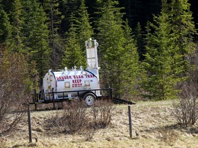A bear trap and signs set up just southwest of Water Valley where a woman was attacked and killed by a grizzly bear on Wednesday, May 26, 2021.