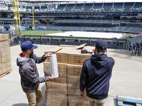 Cleveland Indians employees remove the promotional giveaway items after the game against the Toronto Blue Jays was cancelled due to incoming inclement weather on May 29, 2021 in Cleveland, Ohio.