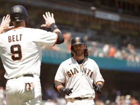Brandon Crawford  of the San Francisco Giants is congratulated by Brandon Belt after he hit a three-run home run in the second inning against the San Diego Padres at Oracle Park on May 08, 2021 in San Francisco.